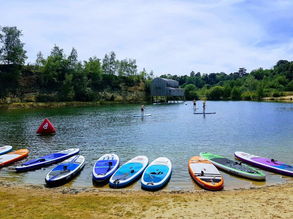 a line of paddleboards along a lake edge watersports lagoon buckland park lake surrey