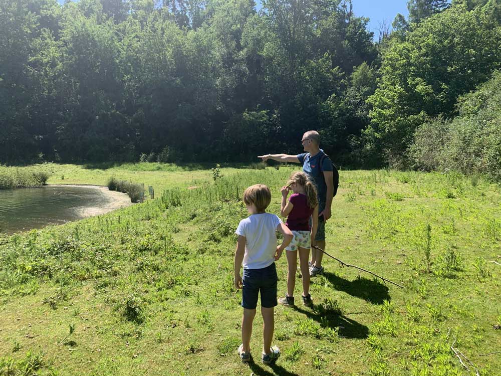 dad-and-two-children-walking-by-the-side-of-a-lake-buckland-park-lake